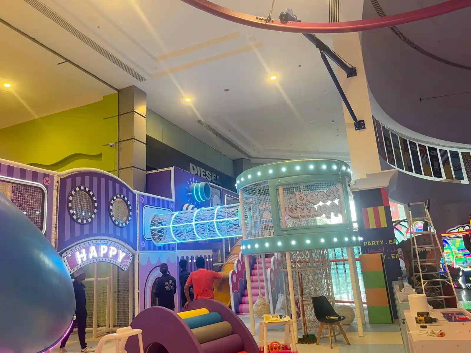 صالة ألعاب داخلية ملونة داخل مركز تجاري تضم هيكل ألعاب متعدد المستويات مع أنفاق شبكية مضيئة وزحاليق ومنطقة تسلق