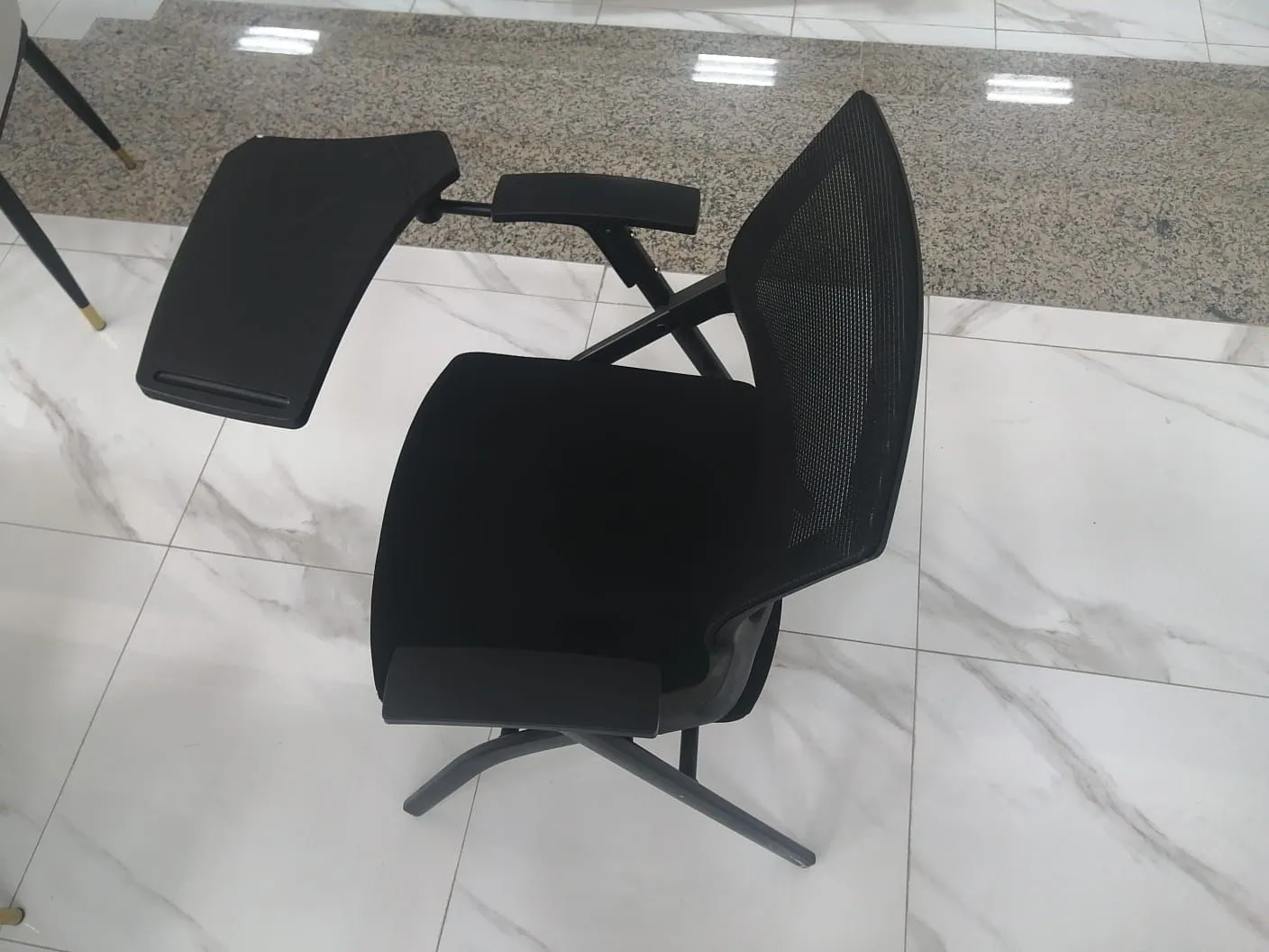 كرسي أسود مزود بطاولة جانبية قابلة للحركة ضمن تجهيزات المدارس الحديثة في السعودية