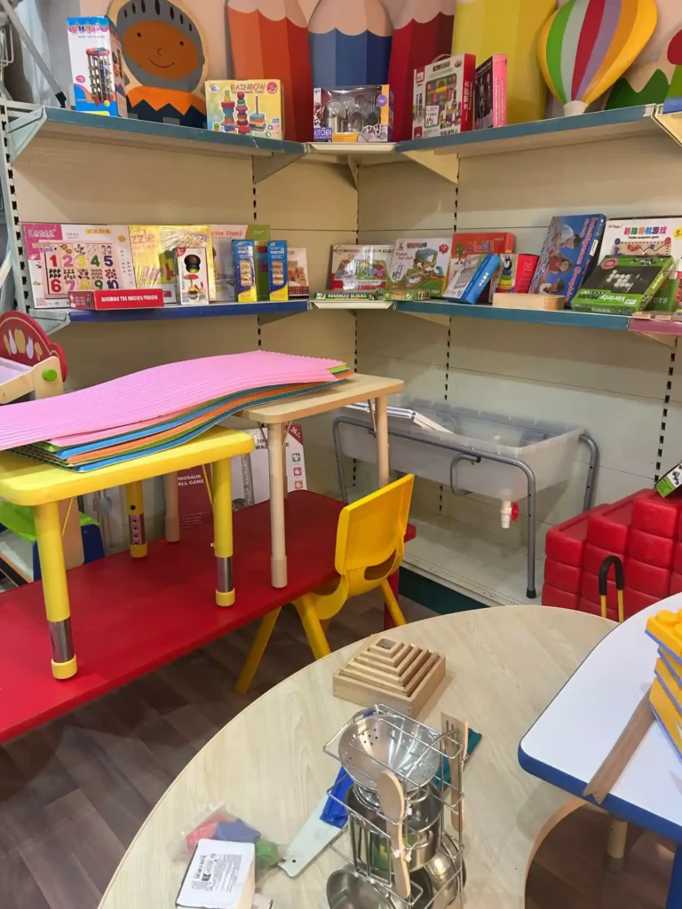 زاوية داخل تجهيزات روضات الأطفال تحتوي على طاولات وكراسي صغيرة ملونة وألعاب تعليمية